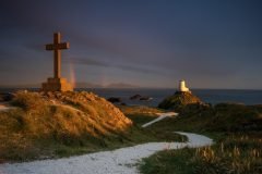 Twr Mawr Lighthouse Llanddwyn Island with spectacular rainbow over the mountains of Snowdonia Eryri