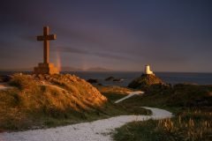 Twr Mawr Lighthouse Llanddwyn Island with spectacular rainbow over the mountains of Snowdonia Eryri