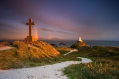 Twr Mawr Lighthouse Llanddwyn Island with spectacular rainbow over the mountains of Snowdonia Eryri