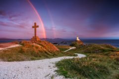 Twr Mawr Lighthouse Llanddwyn Island with spectacular rainbow over the mountains of Snowdonia Eryri