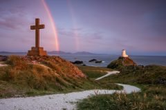 Twr Mawr Lighthouse Llanddwyn Island with spectacular rainbow over the mountains of Snowdonia Eryri